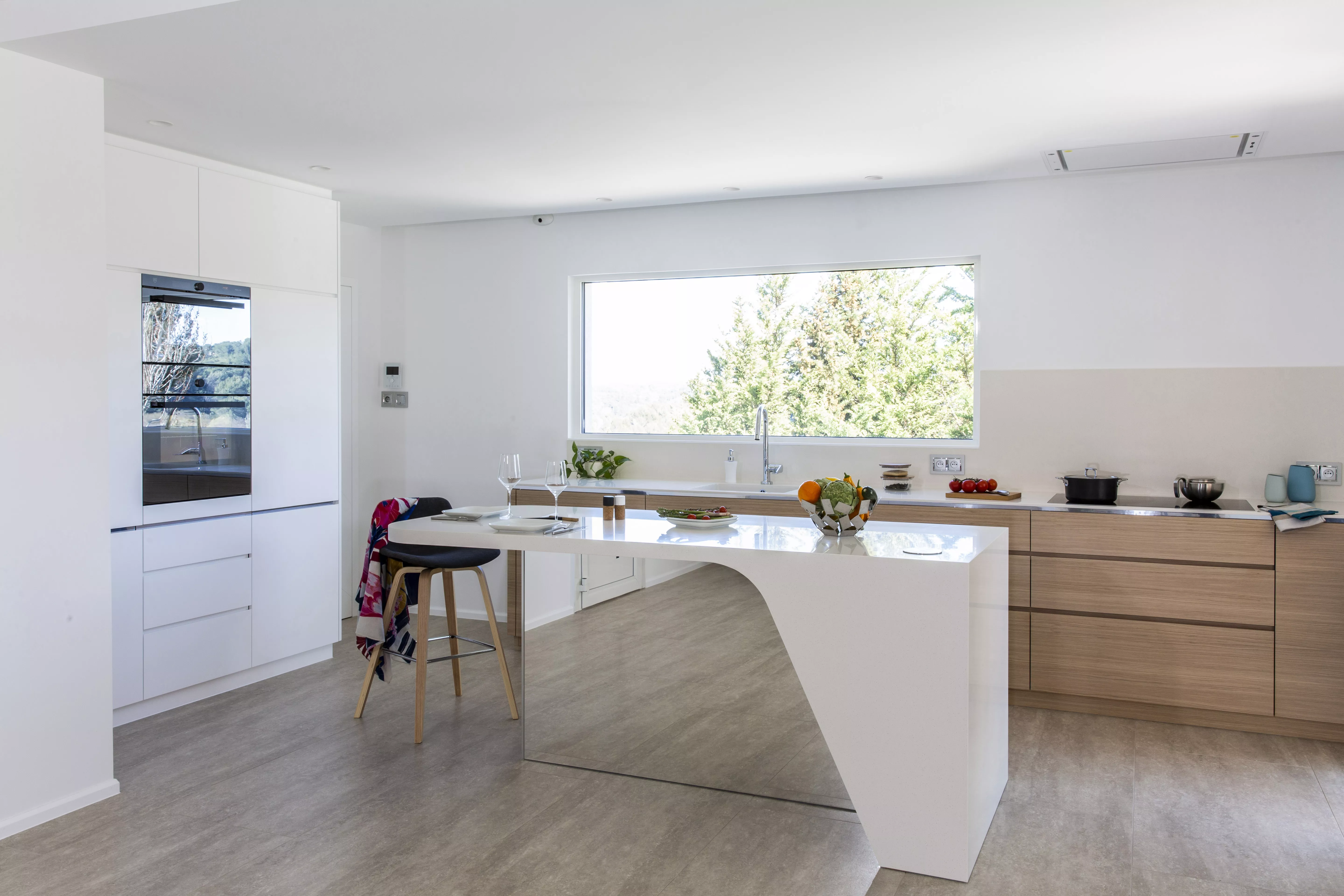 A contemporary, light-filled HIMACS kitchen with a mountain view